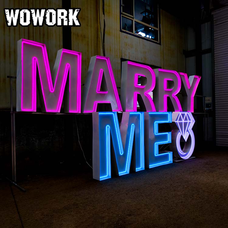 Large light up marquee letters glowing at an outdoor wedding