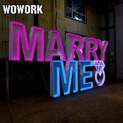 Large light up marquee letters glowing at an outdoor wedding